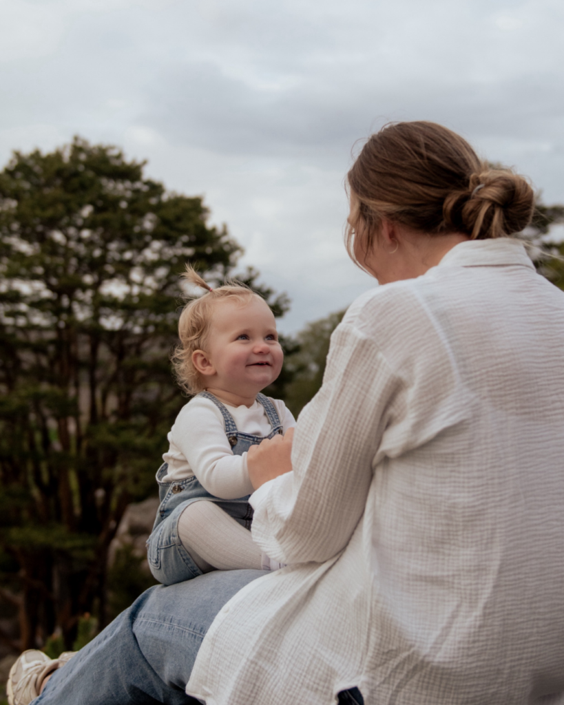 Mor og datter sidder og smiler til hinanden