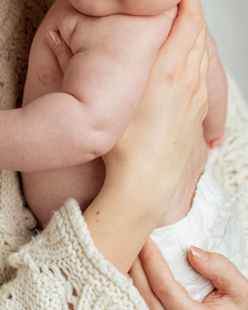 Mor holder sin baby i favnen